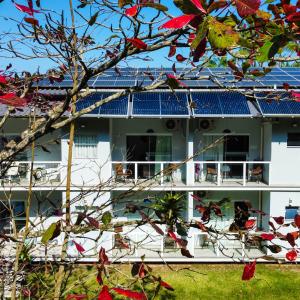a white building with blue solar panels on it at Pousada Cantinho da Praia in Paraty +80 photos