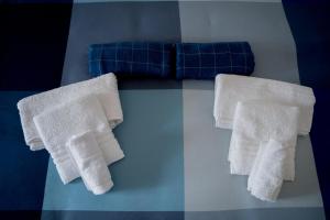 zwei weiße Handtücher auf einem Tisch mit blauem Sofa in der Unterkunft Lulù House in Ostuni