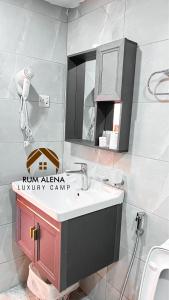 a bathroom with a sink and a mirror at RUM ALIENA LUXURY CAMP in Wadi Rum