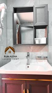 La salle de bains est pourvue d'un lavabo et d'un miroir. dans l'établissement RUM ALIENA LUXURY CAMP, à Wadi Rum