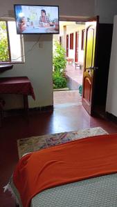 1 dormitorio con TV en la pared y 1 cama en Hospedaje Los Balcones Jumbilla Bongará Amazonas, 