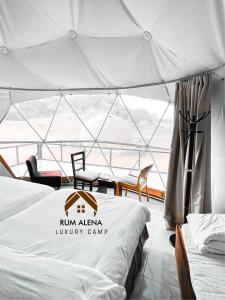 a tent with two beds in a room with a view at RUM ALIENA LUXURY CAMP in Wadi Rum