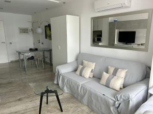 een woonkamer met een grijze bank en een tafel bij Estudios HORIZONTE BEACH in Calpe