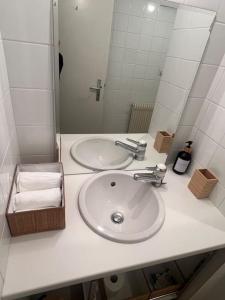 La salle de bains est pourvue d'un lavabo blanc et d'un miroir. dans l'établissement Le nid d’aigle, à Crans-Montana