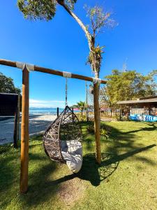 una hamaca balanceándose en un parque con un árbol en Pousada Cantinho da Praia, en Paraty