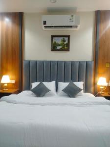 1 dormitorio con 1 cama blanca grande y 2 almohadas en فندق انسام طيبة للضيافة en Medina