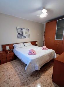 1 dormitorio con 1 cama con 2 toallas rosas en Chalet con piscina privada y barbacoa, en Tarragona