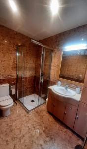 a bathroom with a shower and a toilet and a sink at Chalet con piscina privada y barbacoa in Tarragona