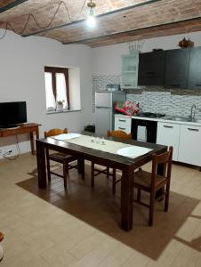eine Küche mit einem Tisch und Stühlen im Zimmer in der Unterkunft La vigna in Costigliole dʼAsti