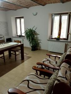 Zimmer mit Stühlen, einem Tisch und Fenstern in der Unterkunft La vigna in Costigliole dʼAsti
