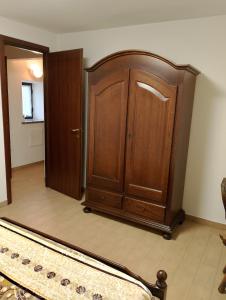 Zimmer mit einem Holzschrank und einer Tür in der Unterkunft La vigna in Costigliole dʼAsti