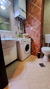 een badkamer met een wasmachine en een toilet bij LERA Apartment in Zagreb