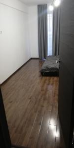 um quarto com uma cama e piso em madeira em Apartament 2 camere Ultracentral em Tîrnăveni