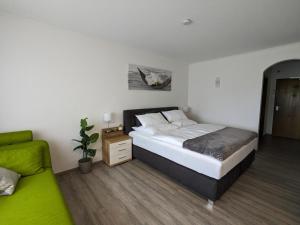 una camera con letto e divano verde di Appartment Haus München a Bad Griesbach im Rottal