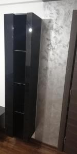 un armario negro con estanterías en una habitación en Apartament 2 camere Ultracentral, en Tîrnăveni