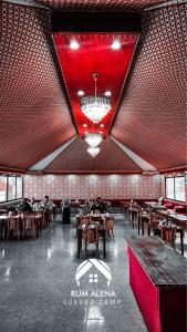 a restaurant with a red ceiling and tables and chairs at RUM ALIENA LUXURY CAMP in Wadi Rum