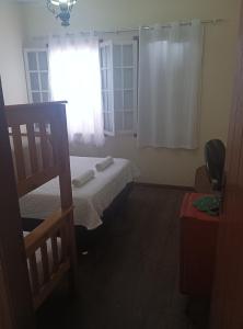 um pequeno quarto com uma cama e uma janela em CASA RAIZ cama, café e prosa em Ouro Preto