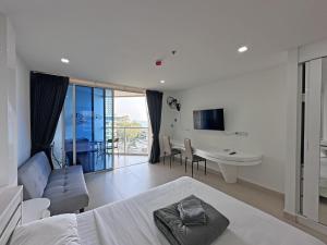 a bedroom with a bed and a living room with a table at Sands Condo Studio 73 by ThaiminatorPattaya in Pattaya South