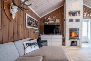 ein Wohnzimmer mit einem Sofa und einem Kamin in der Unterkunft A wonderful estate of two houses for all seasons! in Trysil
