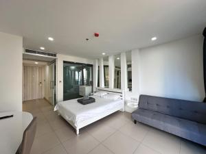 a bedroom with a bed and a couch at Sands Condo Studio 73 by ThaiminatorPattaya in Pattaya South