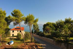 ein Haus mit rotem Dach neben einer Straße in der Unterkunft Apartment Mariner in Sutivan