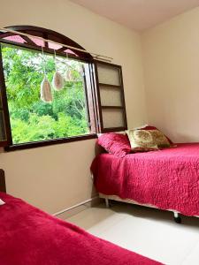 um quarto com duas camas e uma janela em Green House saqua em Saquarema