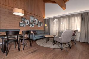 un soggiorno con un divano, un tavolo e delle sedie di Hotel Simi a Zermatt