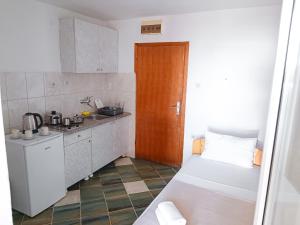 uma pequena cozinha com um lavatório e uma porta de madeira em Amisos Boutique Hotel em Bečići