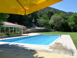 a swimming pool in front of a house at Gerês Adelaide Studios in Geres