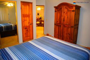a bedroom with a bed and a wooden cabinet at Marina Pinacate Villa-12 in Puerto Peñasco