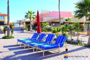 a group of blue beach chairs and a red umbrella at Marina Pinacate Villa-12 in Puerto Peñasco