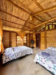 Cabañas Los Pomarrosos في Utica: غرفة نوم بسريرين وسقف خشبي