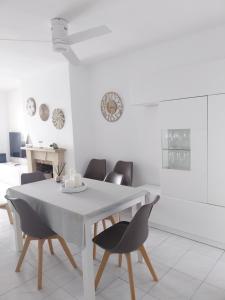 a white dining room with a white table and chairs at Playa Primera Linea Costa Dorada in Comarruga