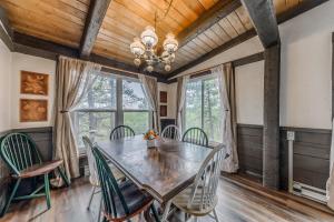 a dining room with a wooden ceiling and a table and chairs at Rustling Pines in Ruidoso