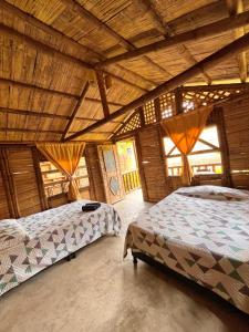 - une chambre avec 2 lits dans une maison en bois dans l'établissement Cabañas Los Pomarrosos, à Utica