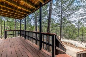 a large deck with a view of the woods at Rustling Pines in Ruidoso