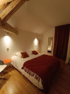 een slaapkamer met een groot bed en een rode deken bij Cosylocation - Vue Théâtre Antique/Jardin de Cybèle in Vienne
