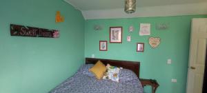 um quarto com uma cama com uma parede verde em Cabaña YaPide em Puerto Varas