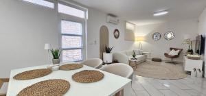 ein weißes Wohnzimmer mit einem Tisch und Stühlen in der Unterkunft Lalic Gallery Apartments in Bibinje