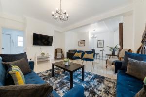 een woonkamer met blauwe banken en een tafel bij 2Bd Flat Opp Harrods - Sleeps 5 in Londen