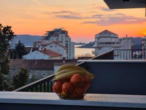 a bowl of fruit sitting on the ledge of a balcony at Adriatic Apartments in Budva