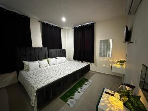1 dormitorio con 1 cama grande y cortinas negras en Hotel Mi Dulce Amanecer PyR, en Nagua