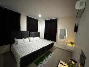 a bedroom with a large bed with black curtains at Hotel Mi Dulce Amanecer PyR in Nagua