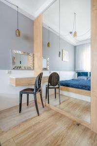 Schlafzimmer mit einem Schreibtisch, einem Bett und einem Stuhl in der Unterkunft Golden Apartments Łodz&G147A in Łódź