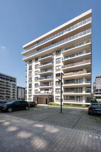 a large building with cars parked in front of it at Golden Apartments Łodz&G147A in Łódź