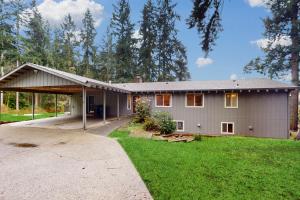 a house with a garage and a grass yard at Pacific Prairie in Woodinville