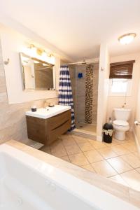 uma casa de banho com uma banheira, um lavatório e um WC. em Elegant & Spacious 3-Bed Space near NYC em Jersey City