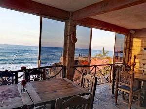 a porch with a wooden table and a view of the ocean at Hotel Gambusino in Lázaro Cárdenas