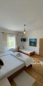 a bedroom with two beds and a window at VILA DISHA in Tirana