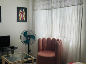 ein Wohnzimmer mit einem Stuhl und einem Ventilator in der Unterkunft Peaceful getaway in Kapstadt